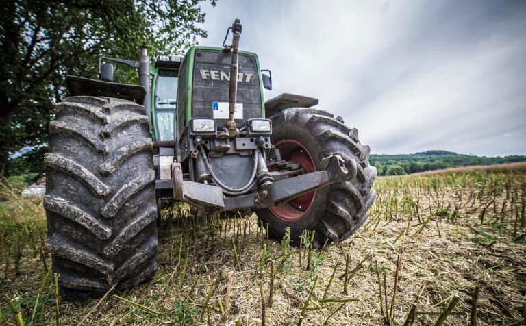 Porównanie dużej, agresywnie bieżnikowanej opony rolniczej (traktor) i solidnej, gładkiej opony przemysłowej (wózek widłowy lub ładowarka).